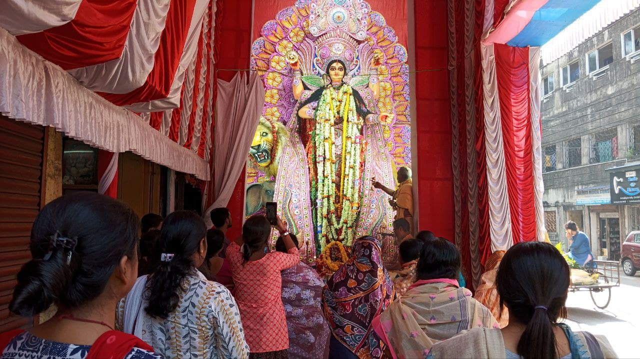 उत्तर कोलकाता में बागबाजार यूनाइटेड की ओर से आयोजित जगद्धात्री पूजा में शामिल लोग और पूजा करते पुजारी। 